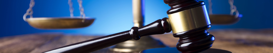 Scales of justice in background with gavel in foreground